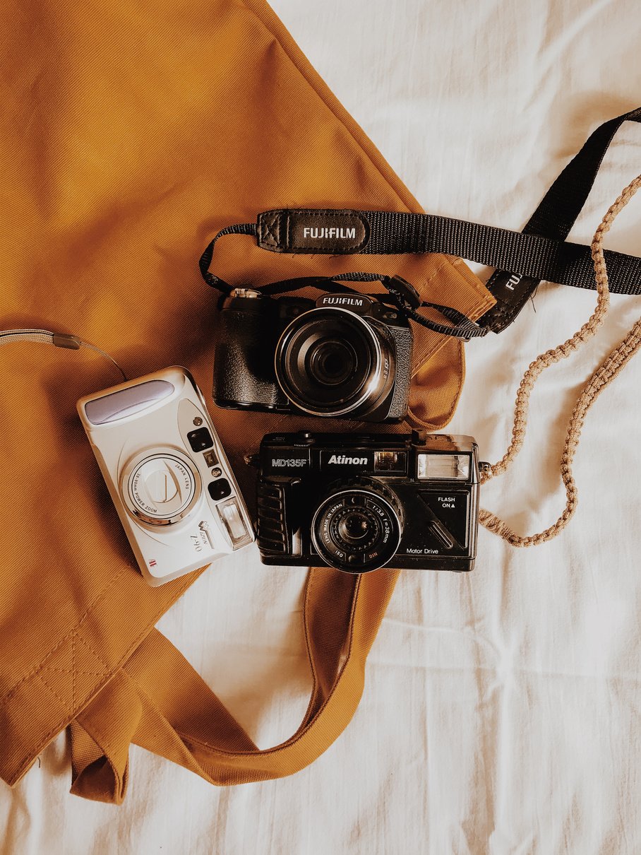 Three Camera on the Top of Brown Leather Bag